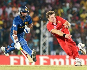 Zimbabwe cricketer Kyle Jarvis (R) throws the ball as Sri Lankan cricketer Kumar Sangakkara (L) runs between the wickets