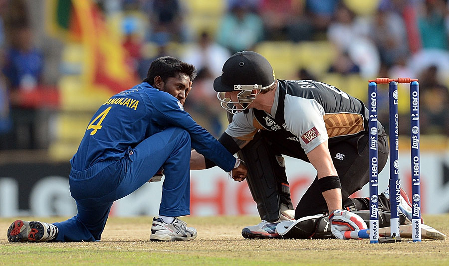 A concerned Brendon McCullum checks on Akila Dananjaya who was hit on the face