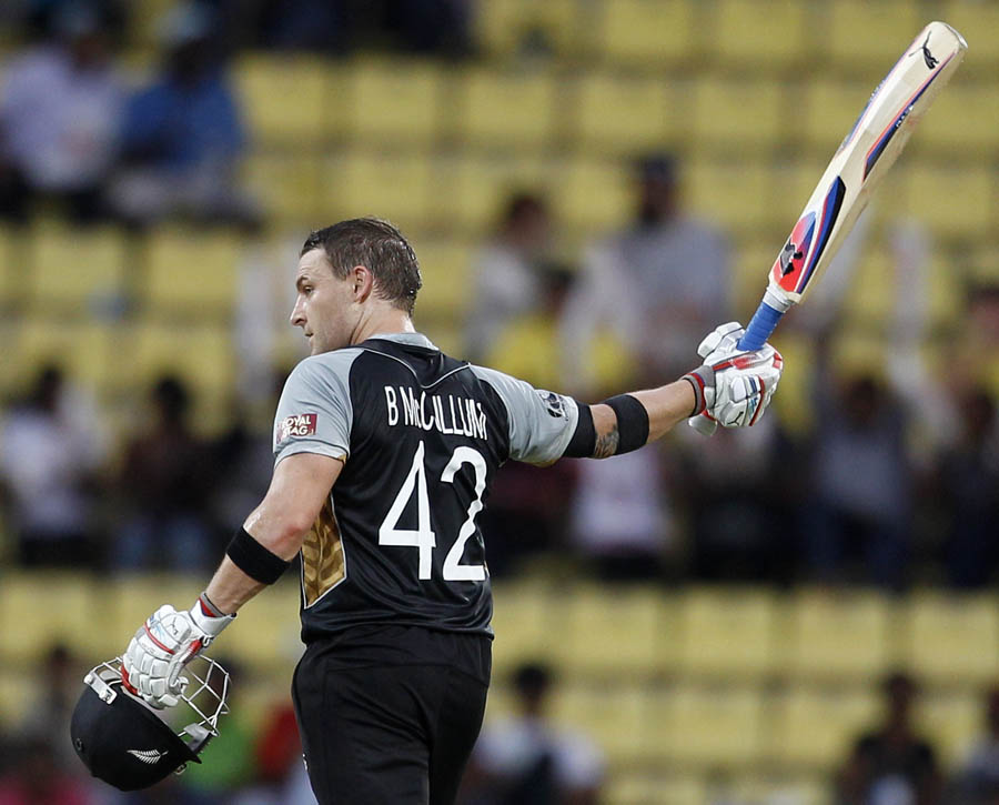 Brendon McCullum raises his bat to celebrate scoring a century during the ICC Twenty20 Cricket World Cup