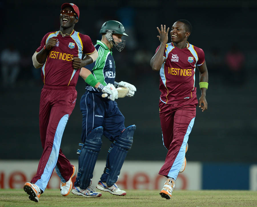 Fidel Edwards of the West Indies celebrates with Darren Sammy after bowling William Porterfield
