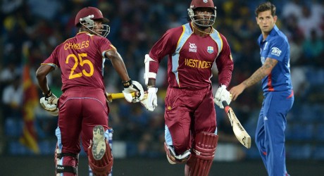 Johnson Charles and Chris Gayle cross as Jade Dernbach looks on
