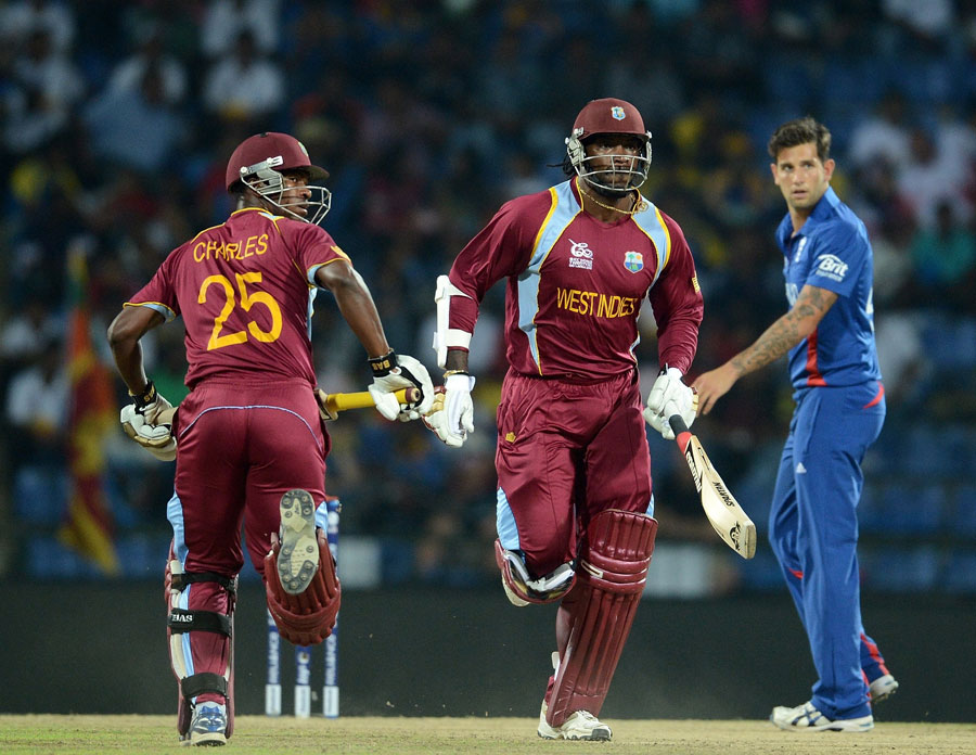 Johnson Charles and Chris Gayle cross as Jade Dernbach looks on