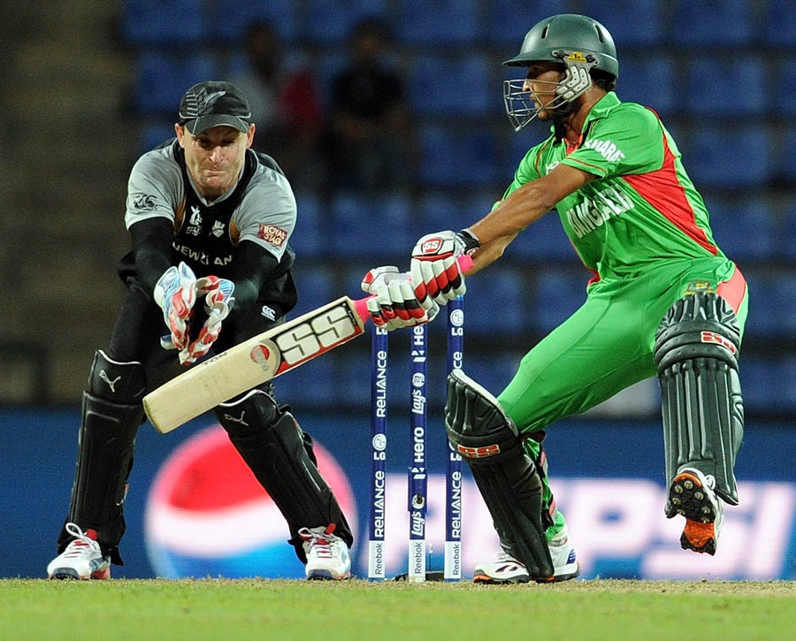 wicketkeeper Brendon McCullum (L) watches as Bangladesh batsman Nasir Hossain plays a shot