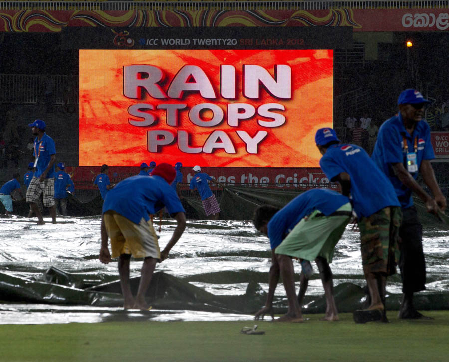 Ground staff pull covers over the ground as rain stops the play during an ICC Twenty20 Cricket World Cup match