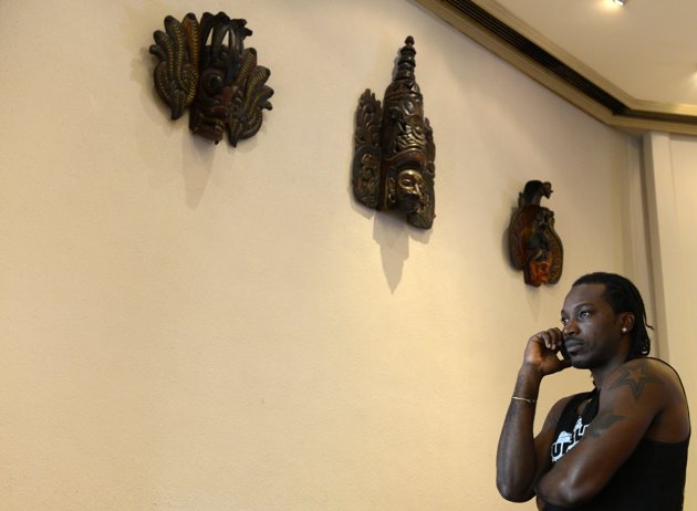 West Indies cricketer Chris Gayle talks on the phone at a hotel lobby