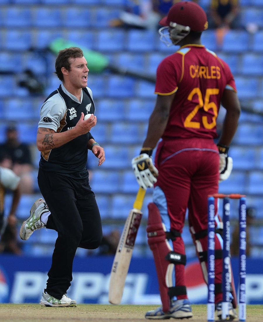 Doug Bracewell (L) celebrates the wicket of West Indies cricketer Johnson Charles (R)