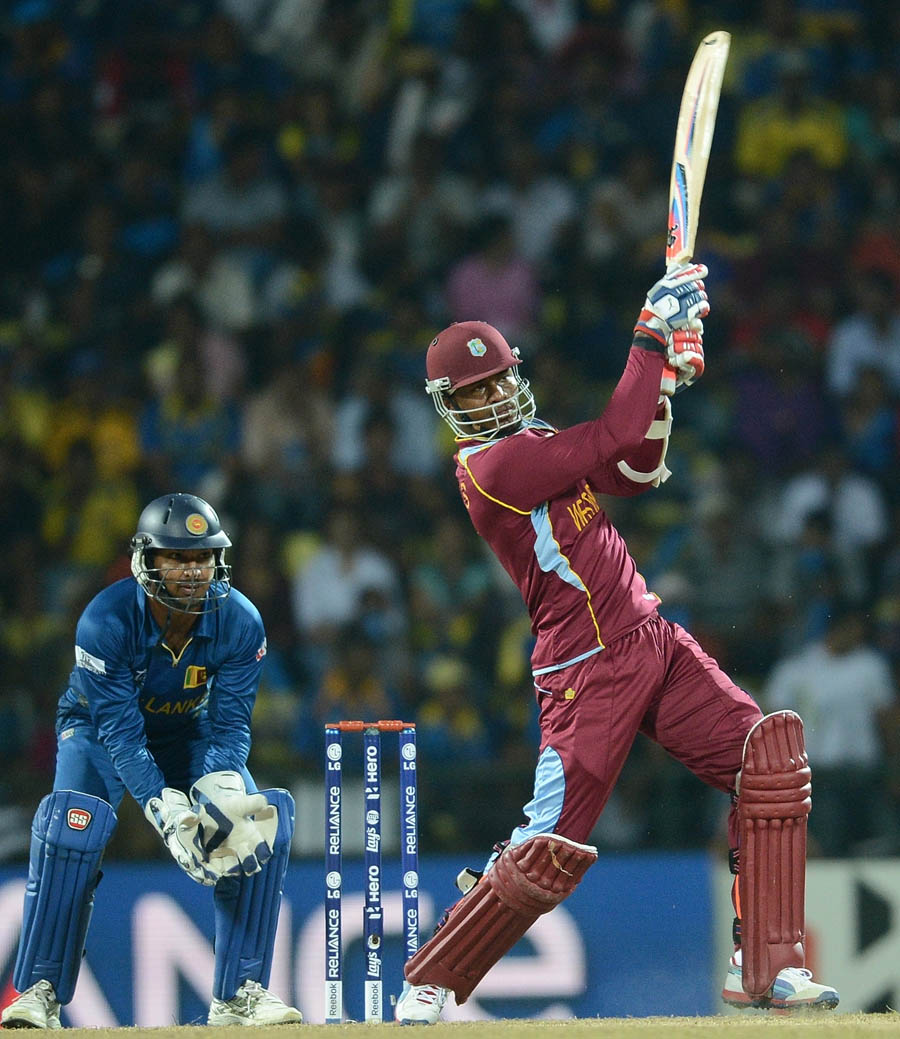 Kumar Sangakkara (L) watches as West Indies batsman Marlon Samuels plays a shot