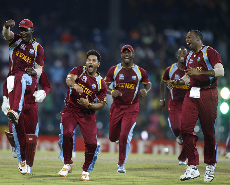 West Indies' bowler Ravi Rampaul, second left without cap, and captain Darren Sammy, left, celebrate with teammates the dismissal of Australia's batsman David Hussey