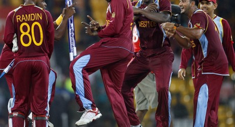 West Indies' cricketer Chris Gayle, center, dances with teammates to celebrate their win over Australia