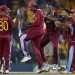 West Indies' cricketer Chris Gayle, center, dances with teammates to celebrate their win over Australia