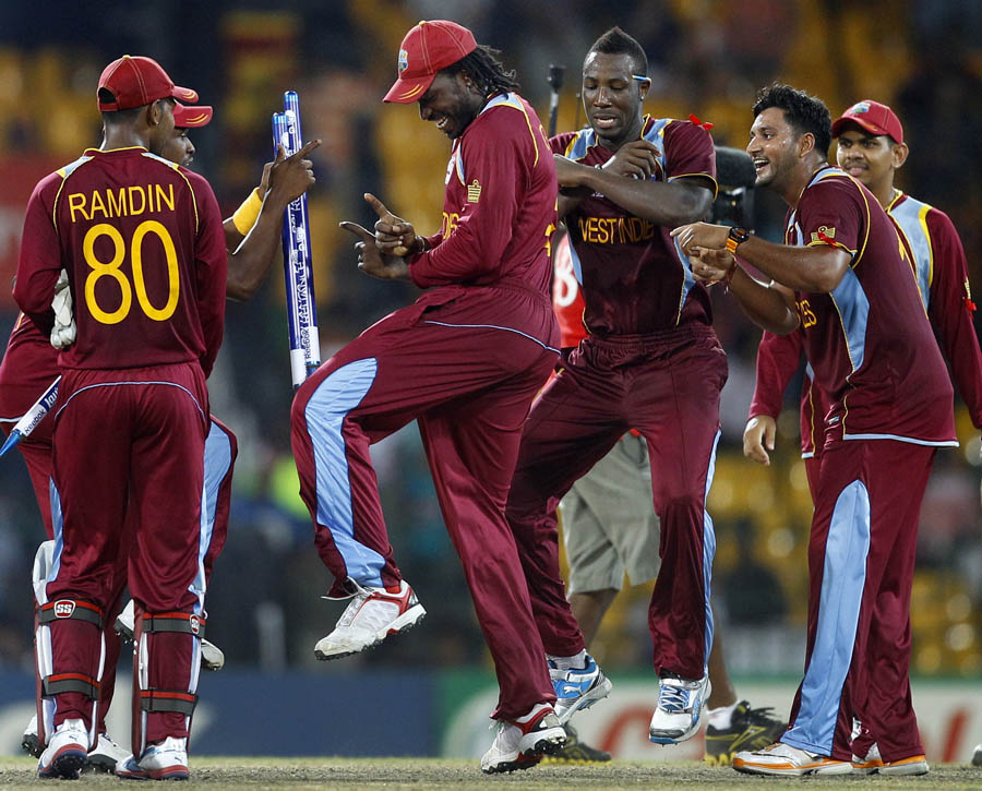 West Indies' cricketer Chris Gayle, center, dances with teammates to celebrate their win over Australia 
