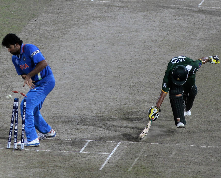 Yasir Arafat, right, unsuccessfully tries to reach the crease as India's bowler Zaheer Khan celebrates the run out